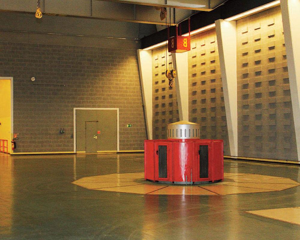 Interior view of machine room with the top of one generating unit visible above the floor